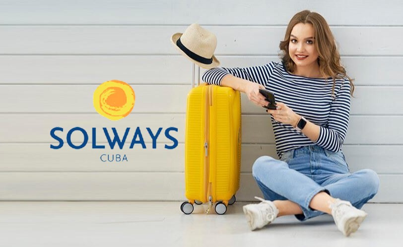 muchacha, maleta de viaje amarilla, sentada en el suelo, logo de Solways Cuba