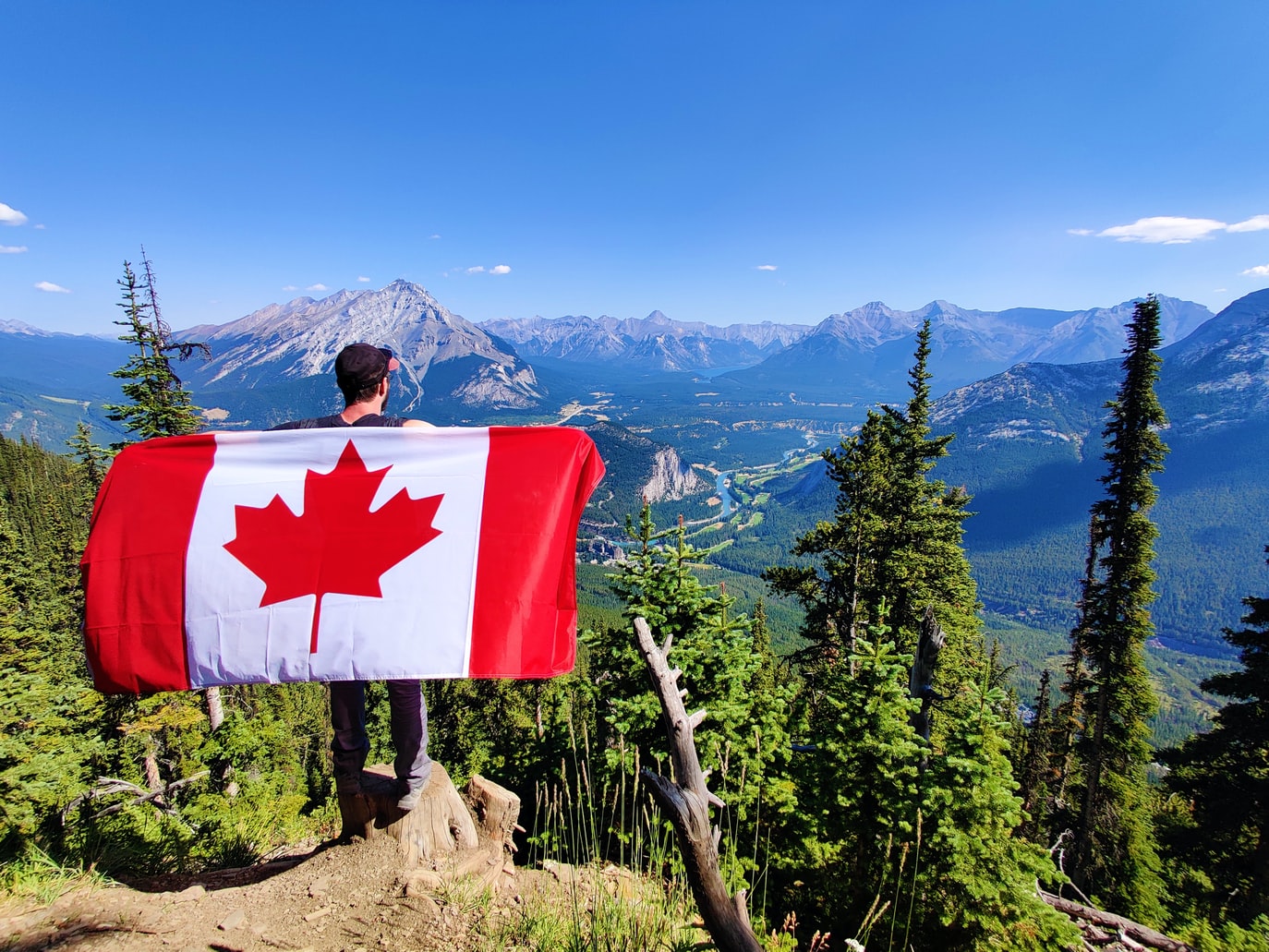 canadienses, hombre con bandera de Canadá mirando paisaje